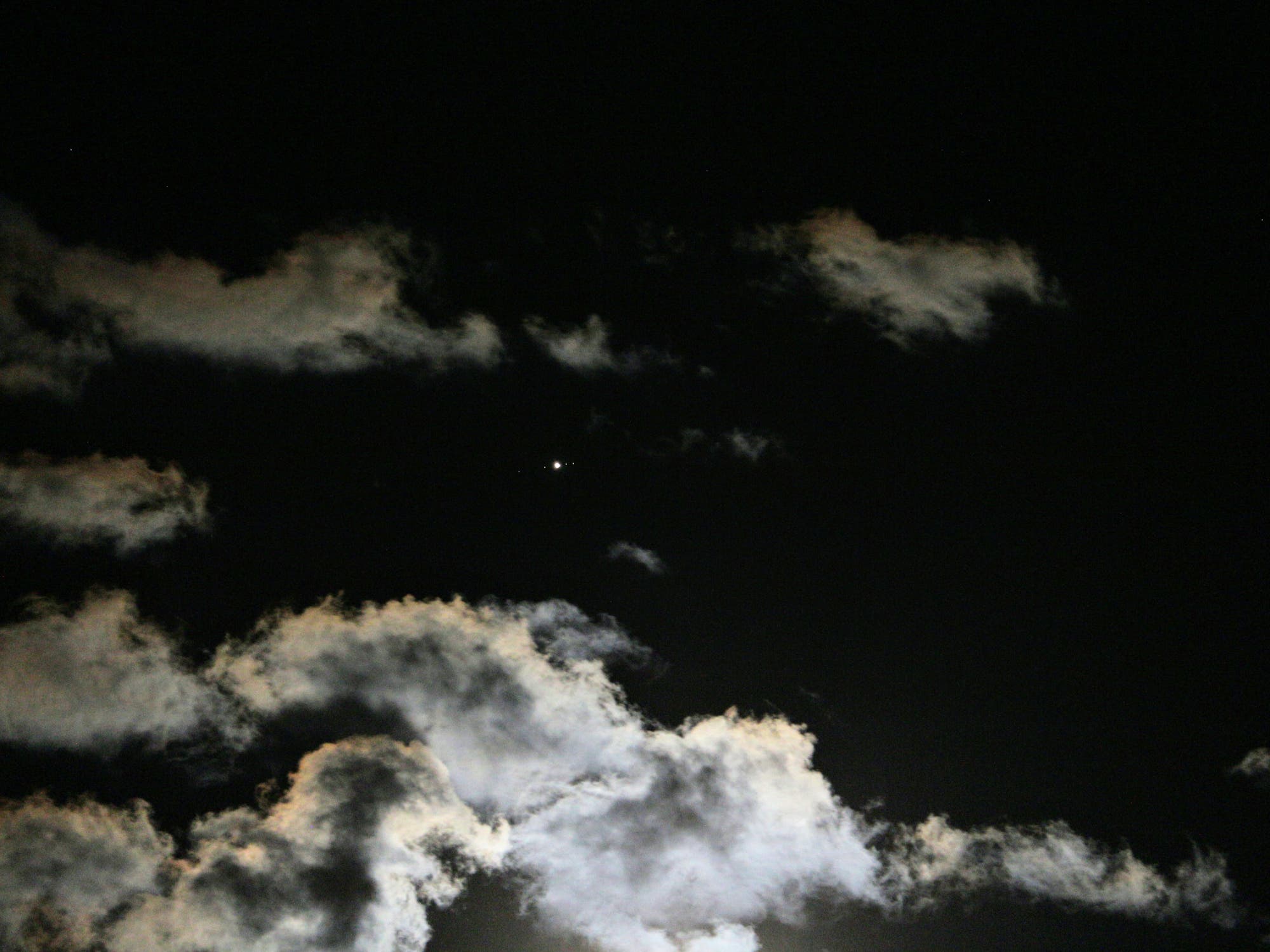 Jupiter über vom Mond beleuchteten Wolken