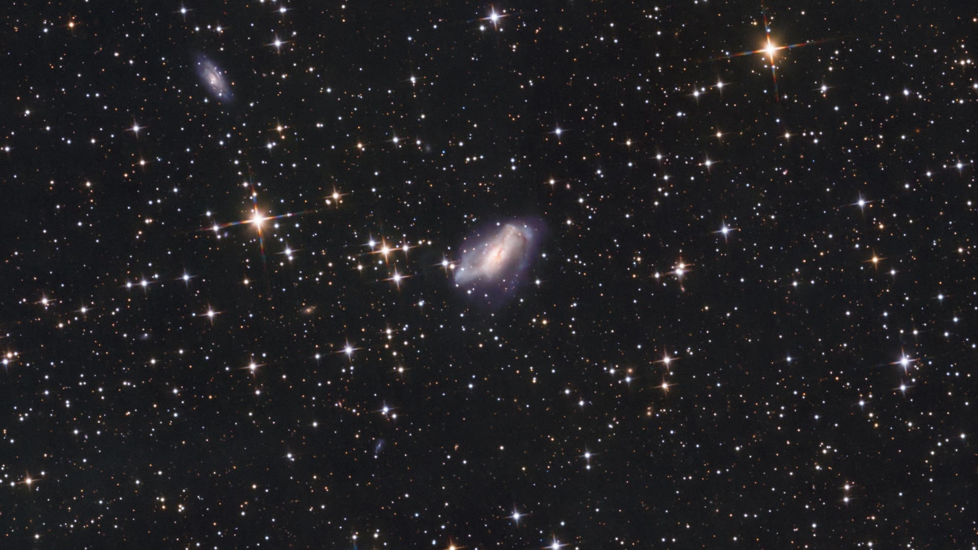 NGC 2146 und dessen Umgebung - Spektrum der Wissenschaft