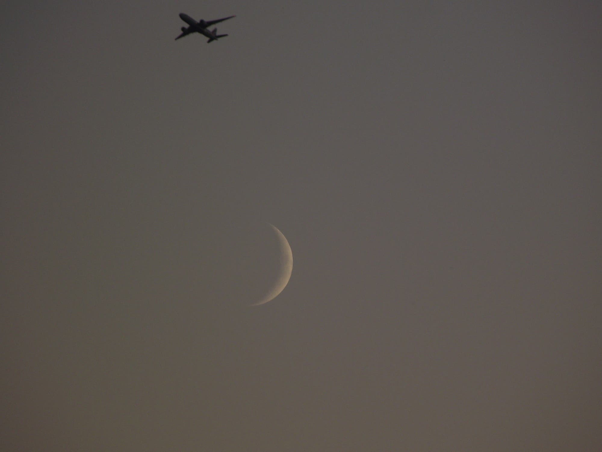 Junge Mondsichel mit Flugzeug 