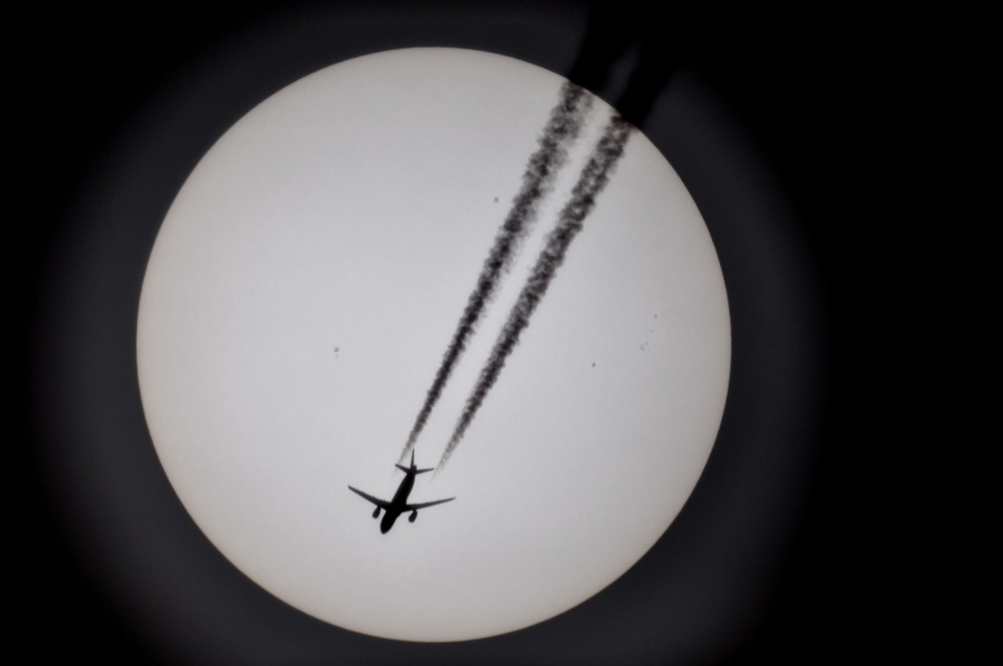 Sonne mit kleinen Sonnenflecken und mit Flugzeug