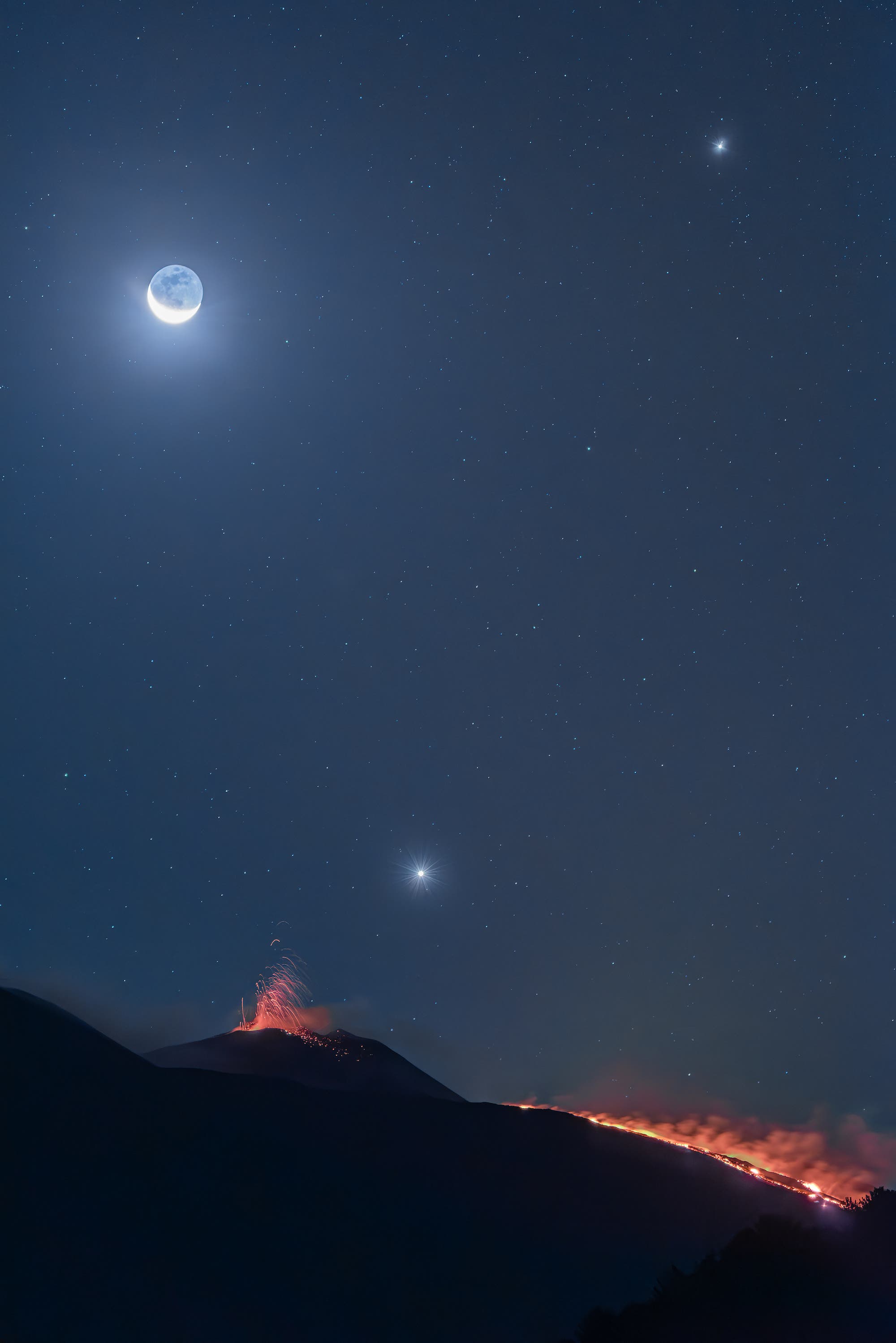 Jupiter, Moon, and Venus conjunct over the erupting volcano Etna