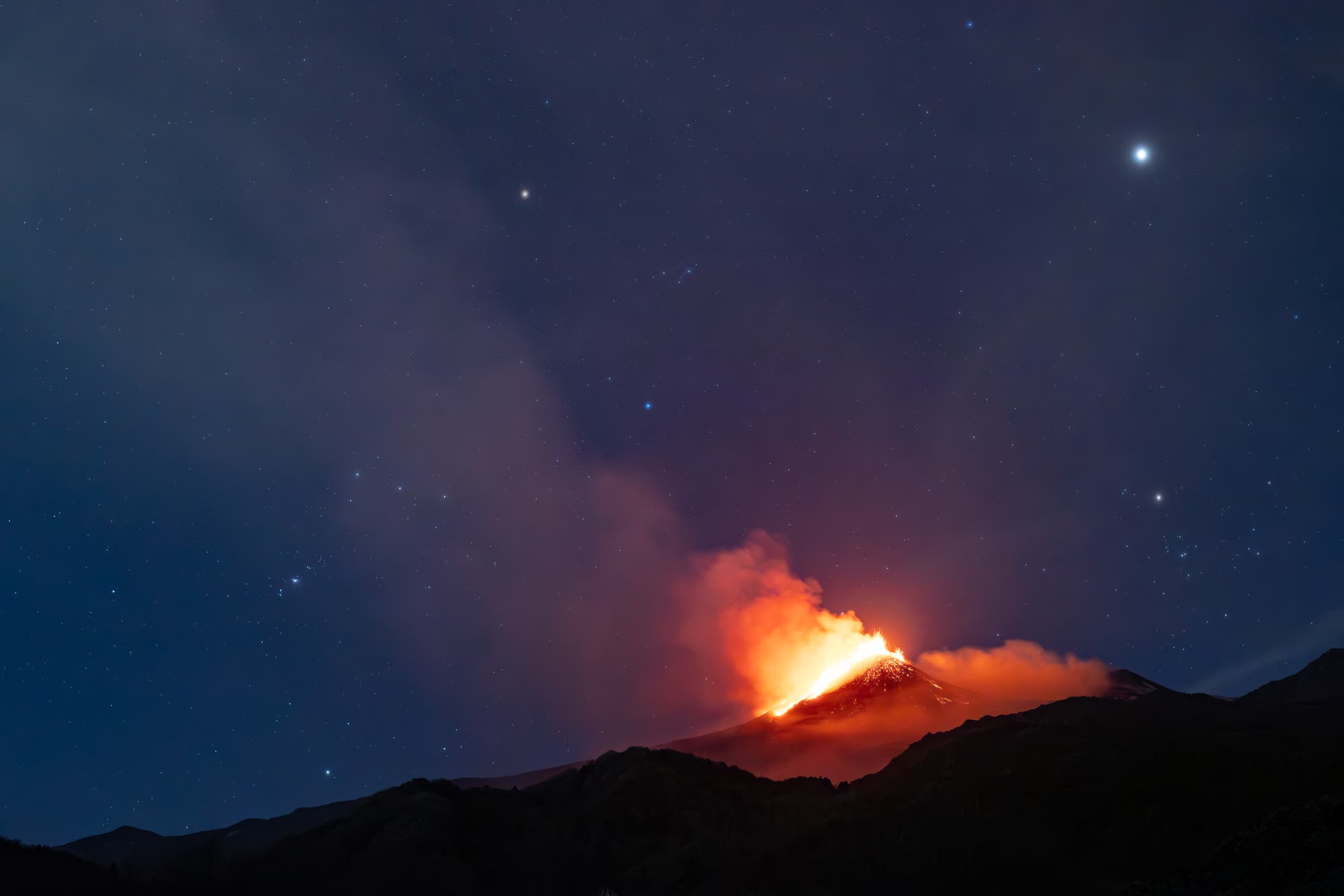 Orion, the hunter, sets over erupting mount Etna