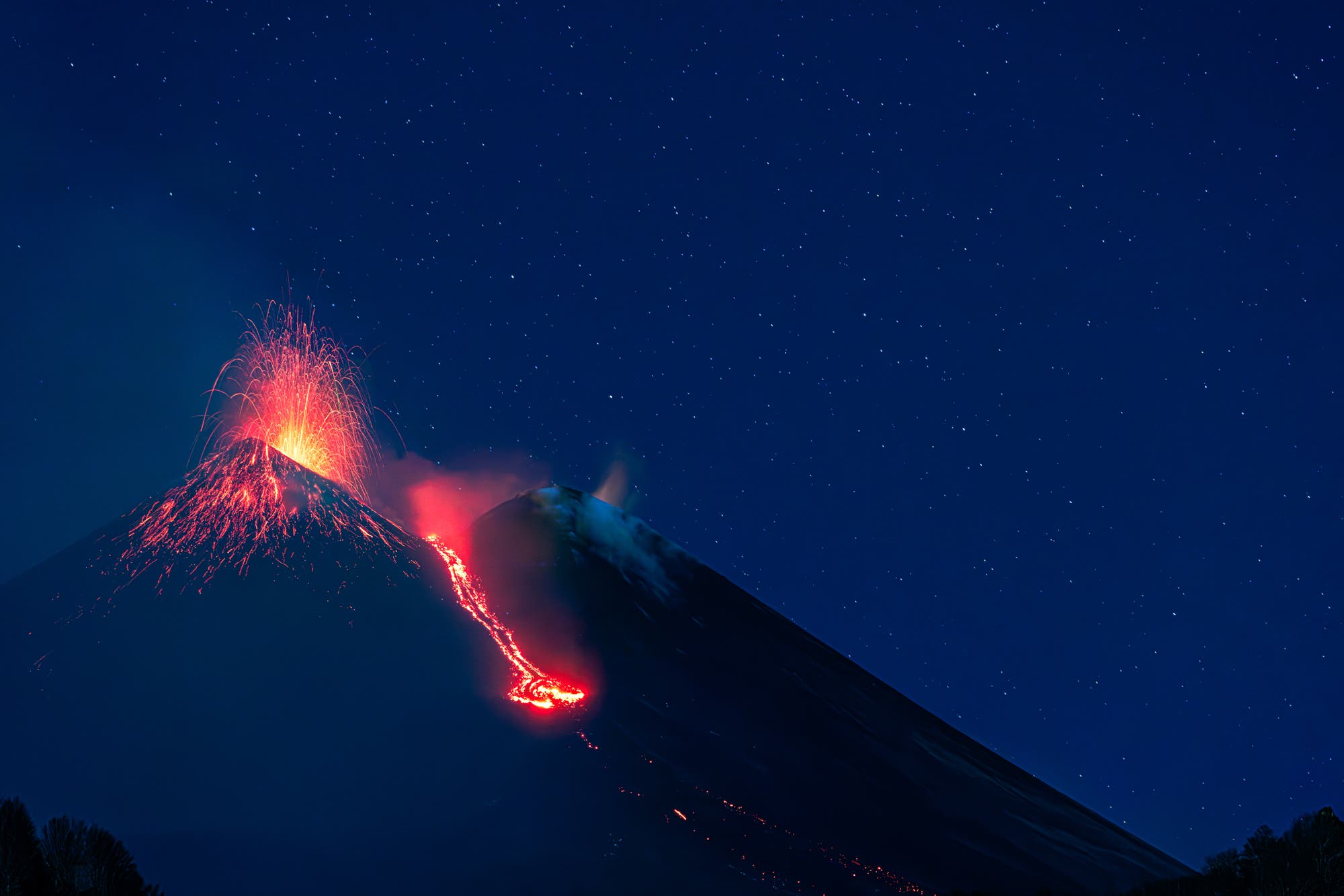 Starry night over erupting Etna