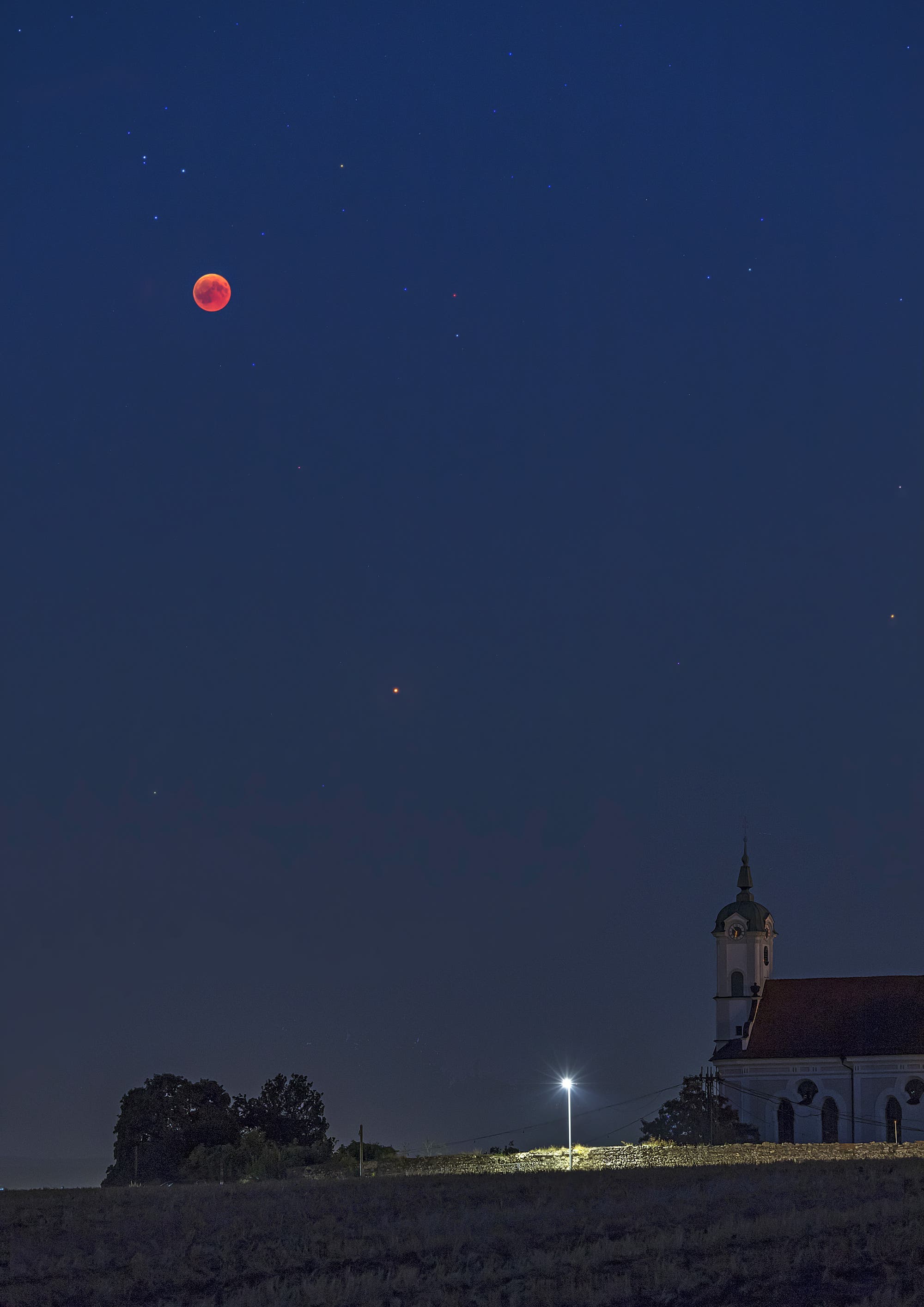 Verfinsterter Mond und Mars über der Klosterkirche von Oberelchingen, Landkreis Neu-Ulm