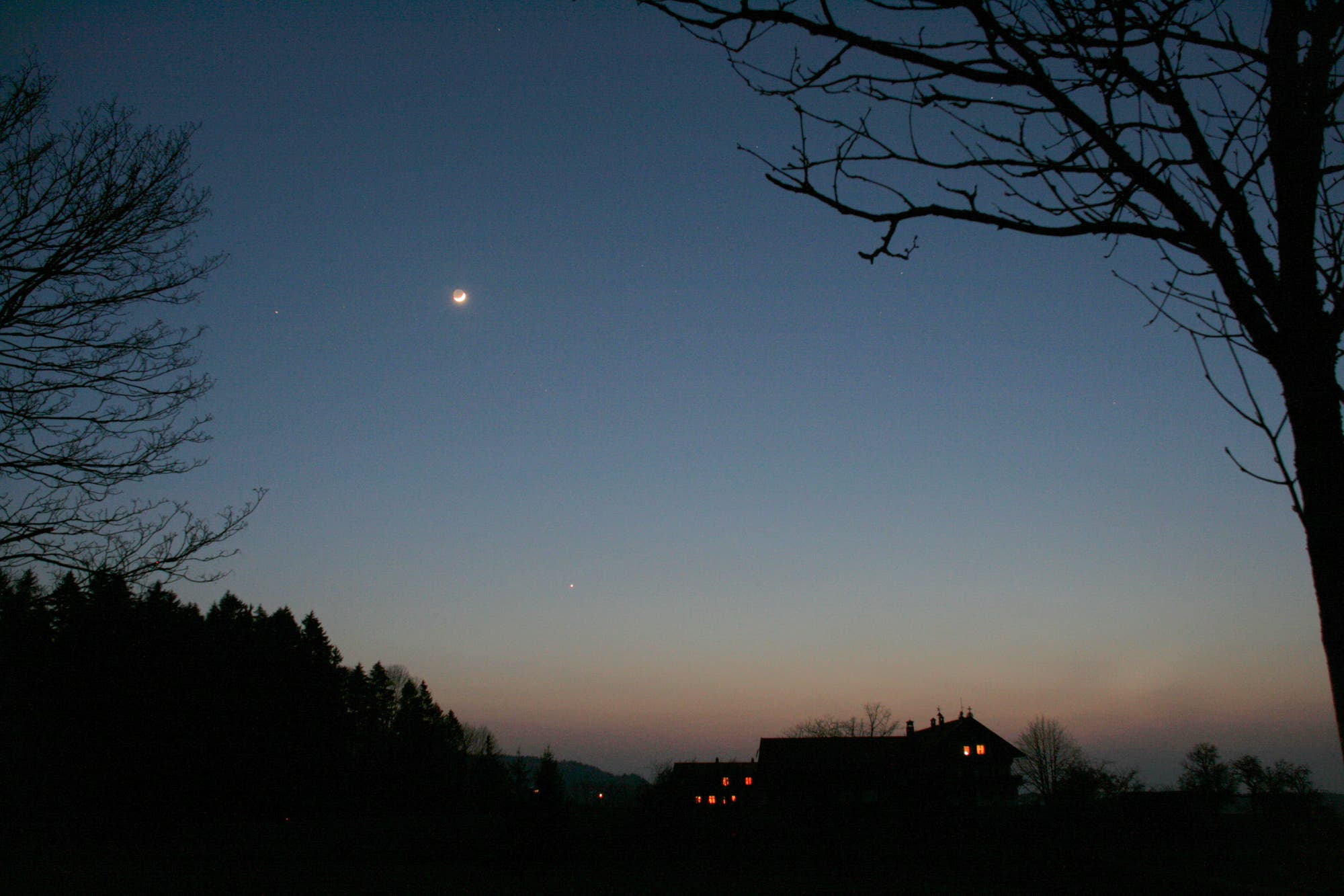 Mond und Venus über Vulkanaschedunst am Horizont