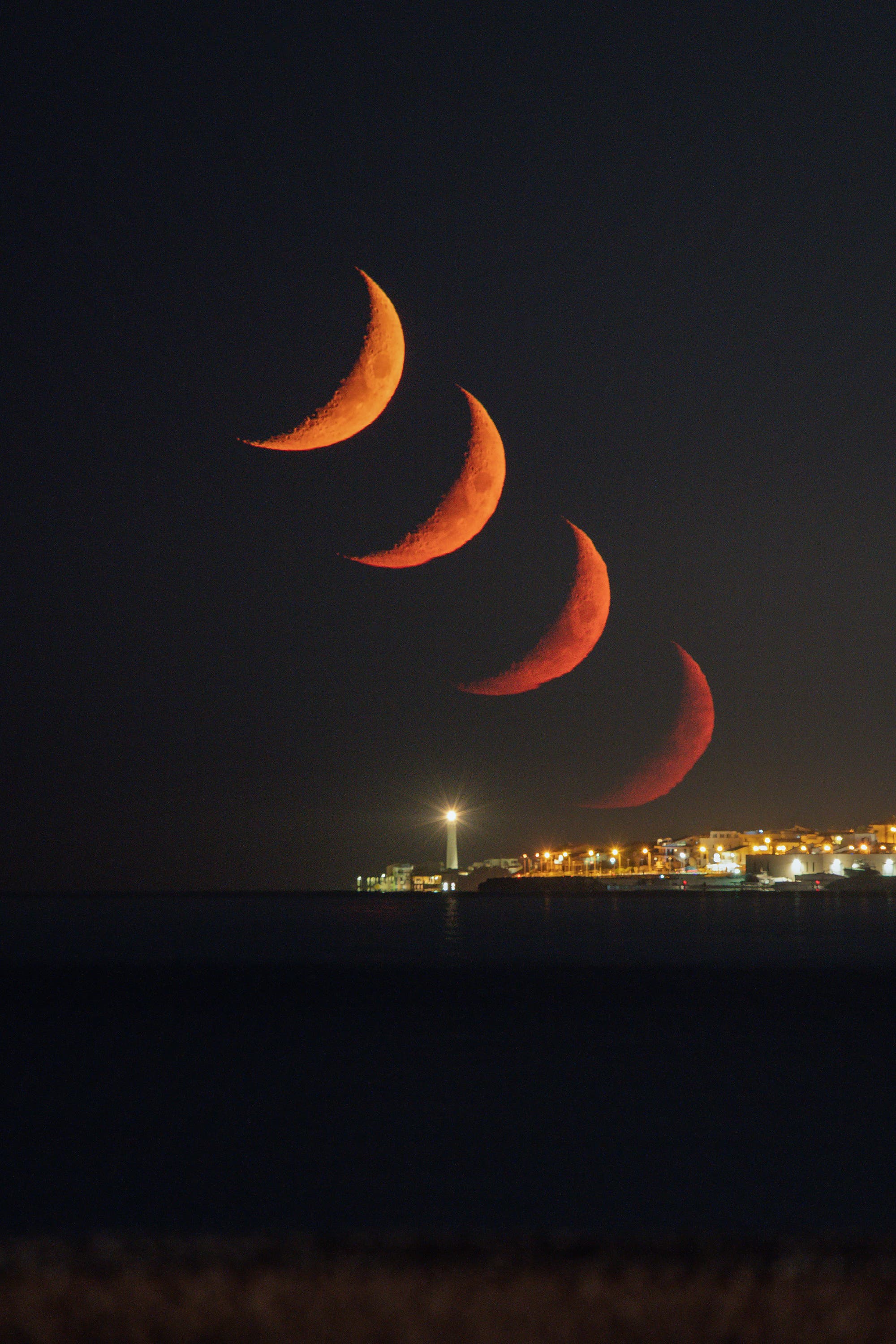 Moon trail over Punta Secca lighthouse (Sicily)