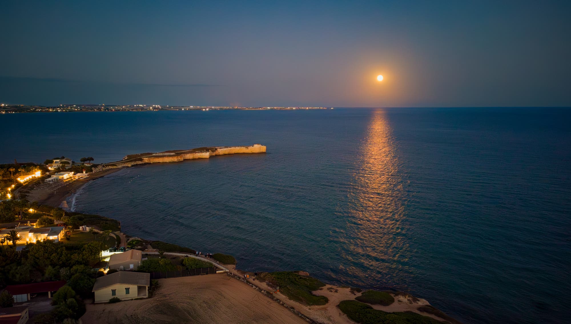 The full moon reflects on the sea at Punta Castellazzo
