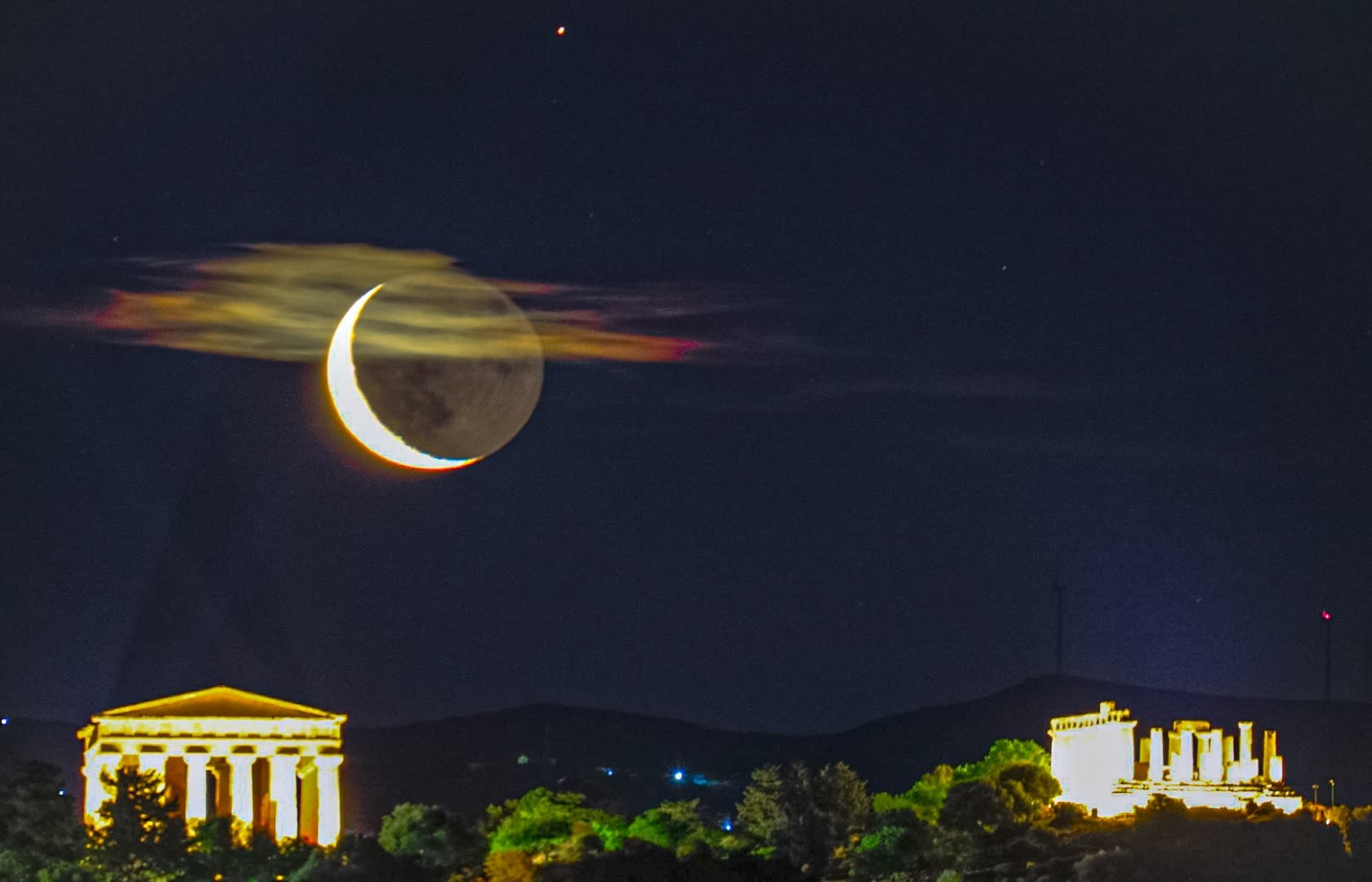 Moon above the temples with iridescent clouds
