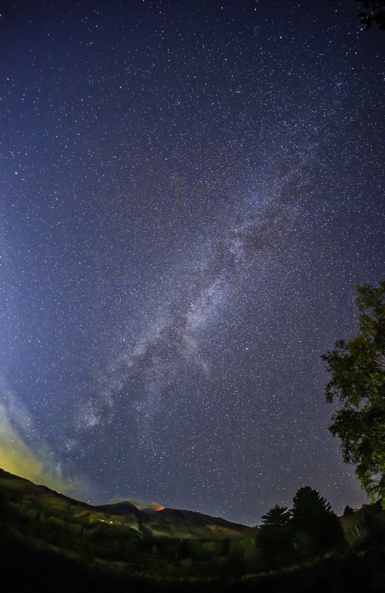 Milky way above erupting Etna volcano Sicily Italy 