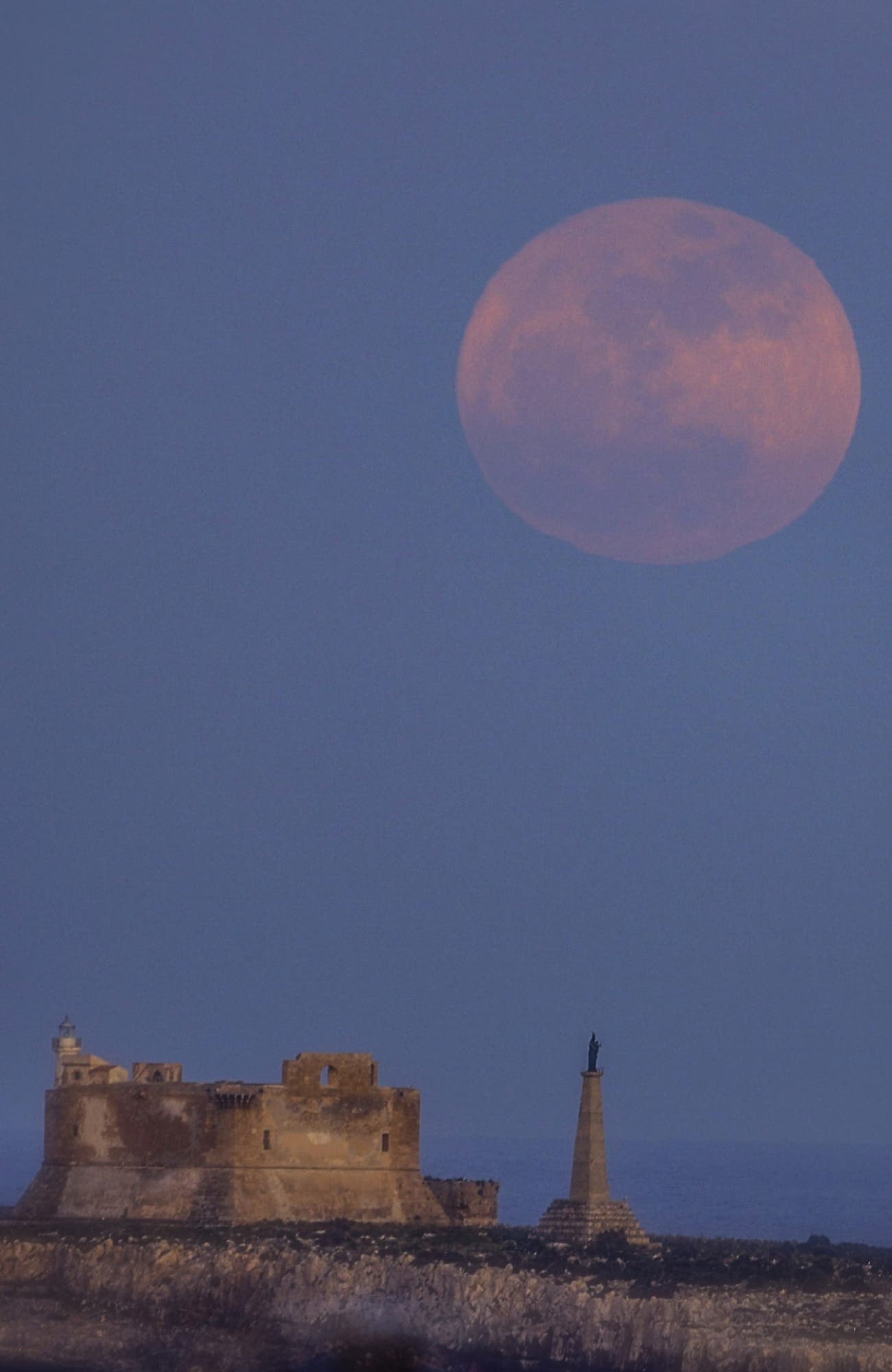 Flower moon rises over the ancient fortress (isola di capo passero Portopalo)