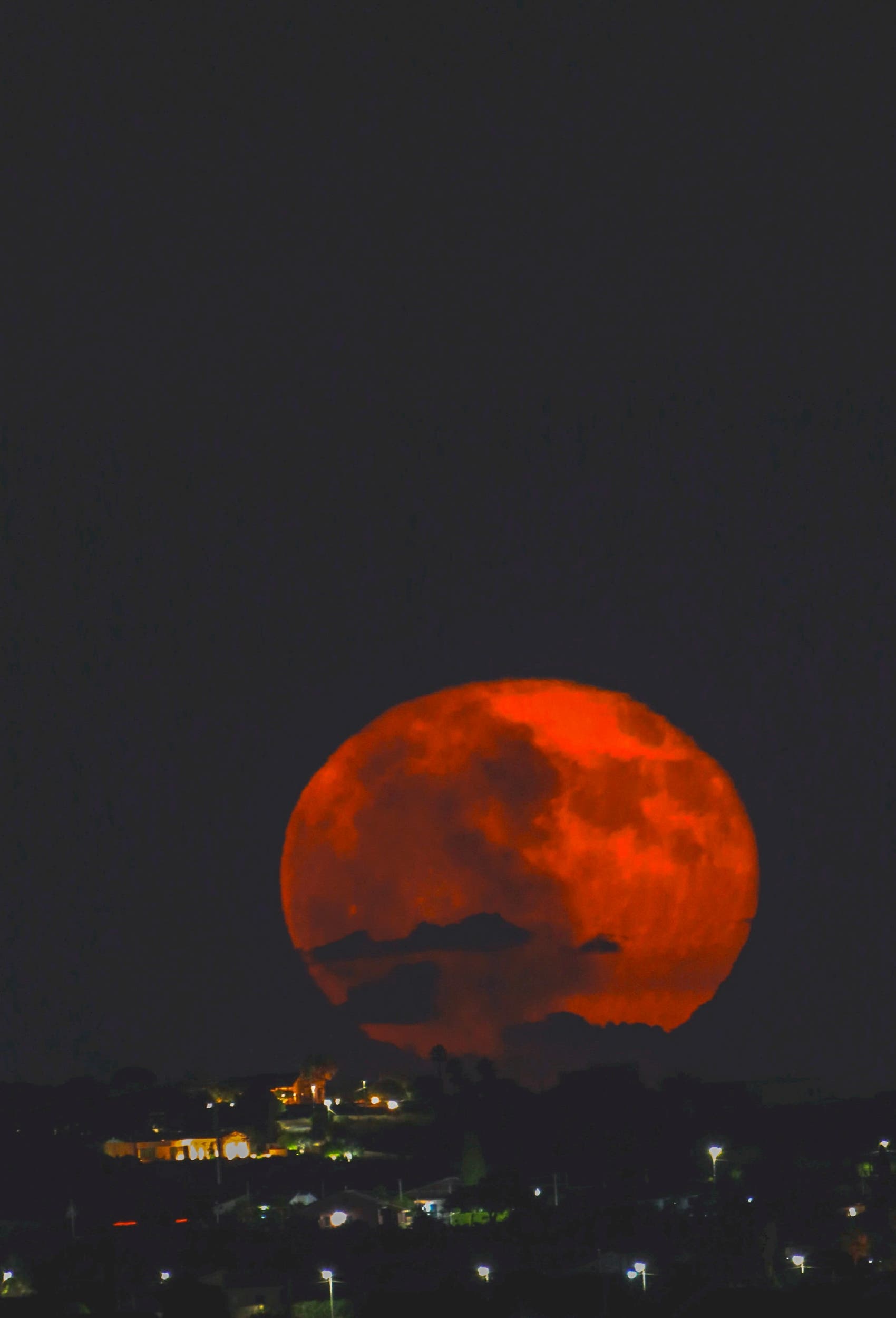 Buck Moon rises above the city of Modica Italy Sicily 