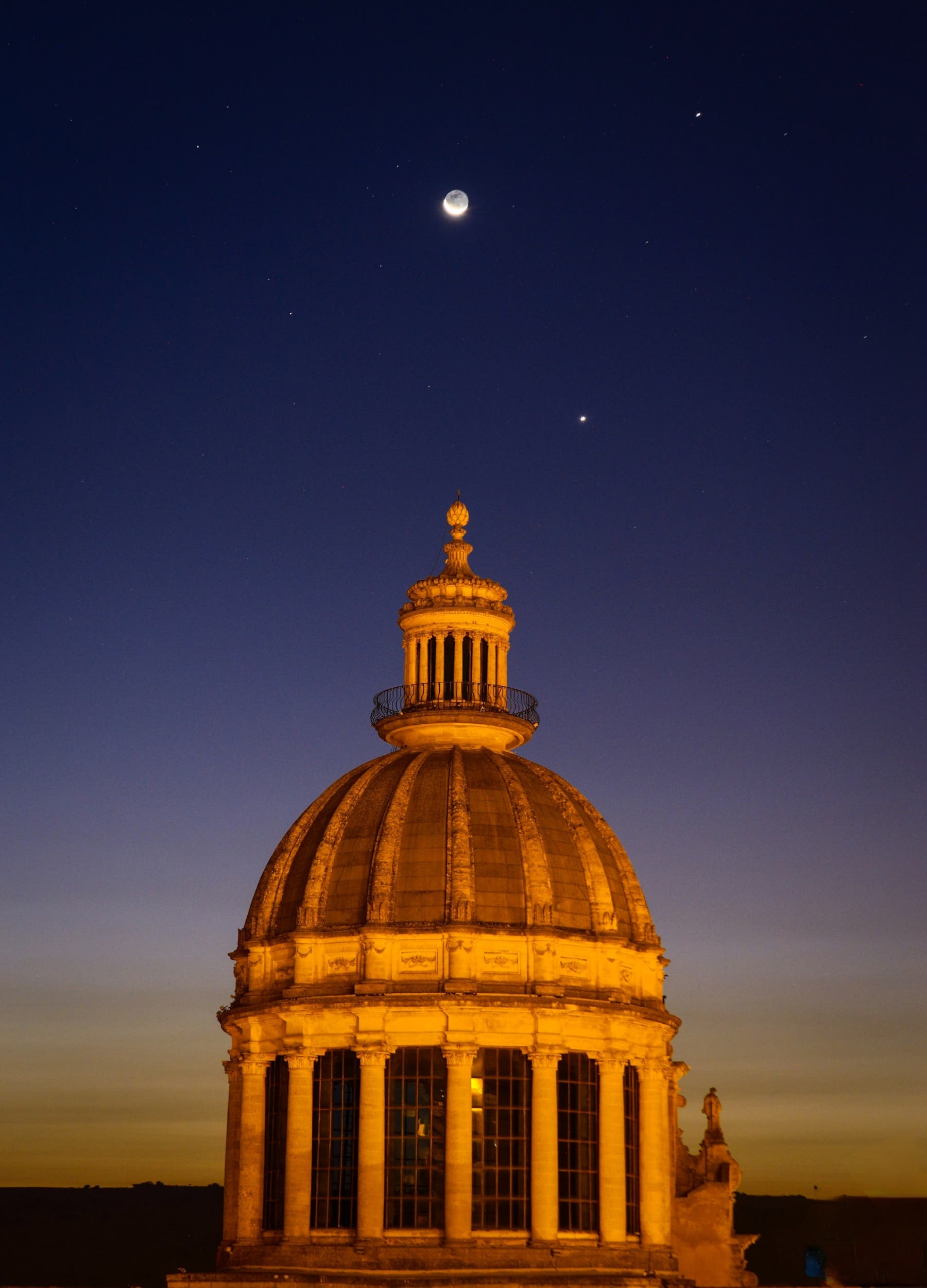 Conjunction alignment Moon, Venus and Jupiter above the baroque dome of Ragusa, Italy 