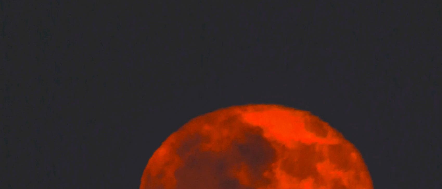 Buck Moon rises above the city of Modica Italy Sicily 