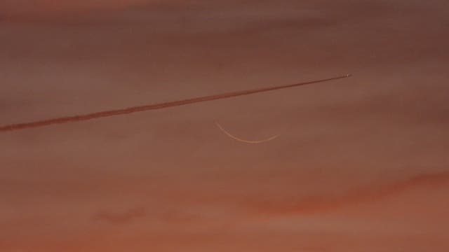 Flugzeug kreuzt liegende Mondsichel -1