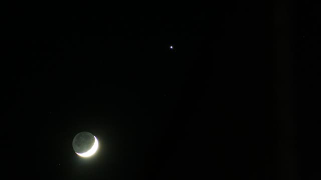 Mond im aschgrauen Licht mit Jupiter