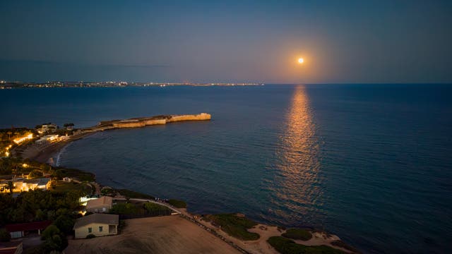 The full moon reflects on the sea at Punta Castellazzo