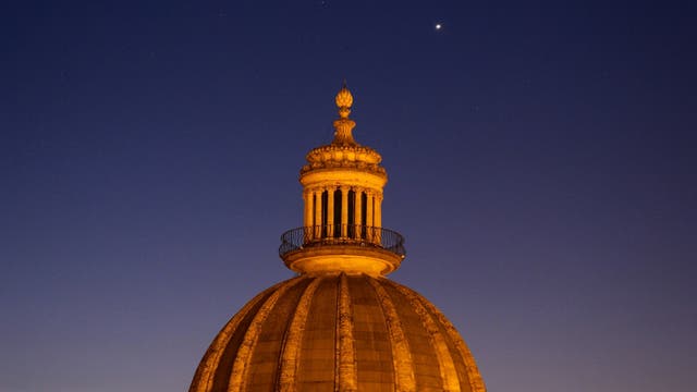 Conjunction alignment Moon, Venus and Jupiter above the baroque dome of Ragusa, Italy 