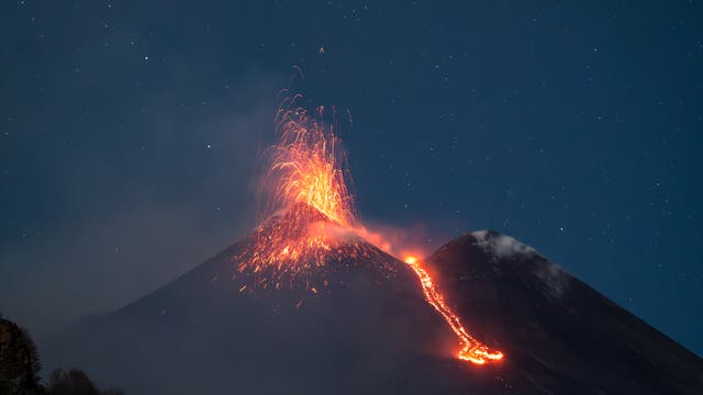 Etna eruption under a magnificent starry sky