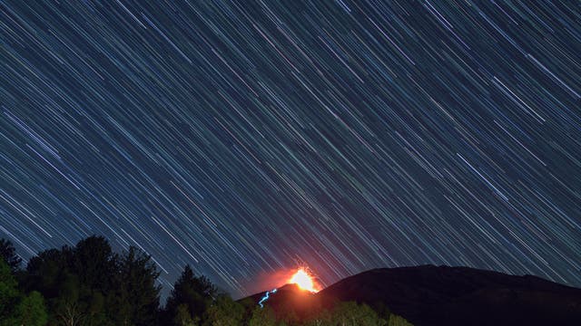 Star trails over Etna eruption