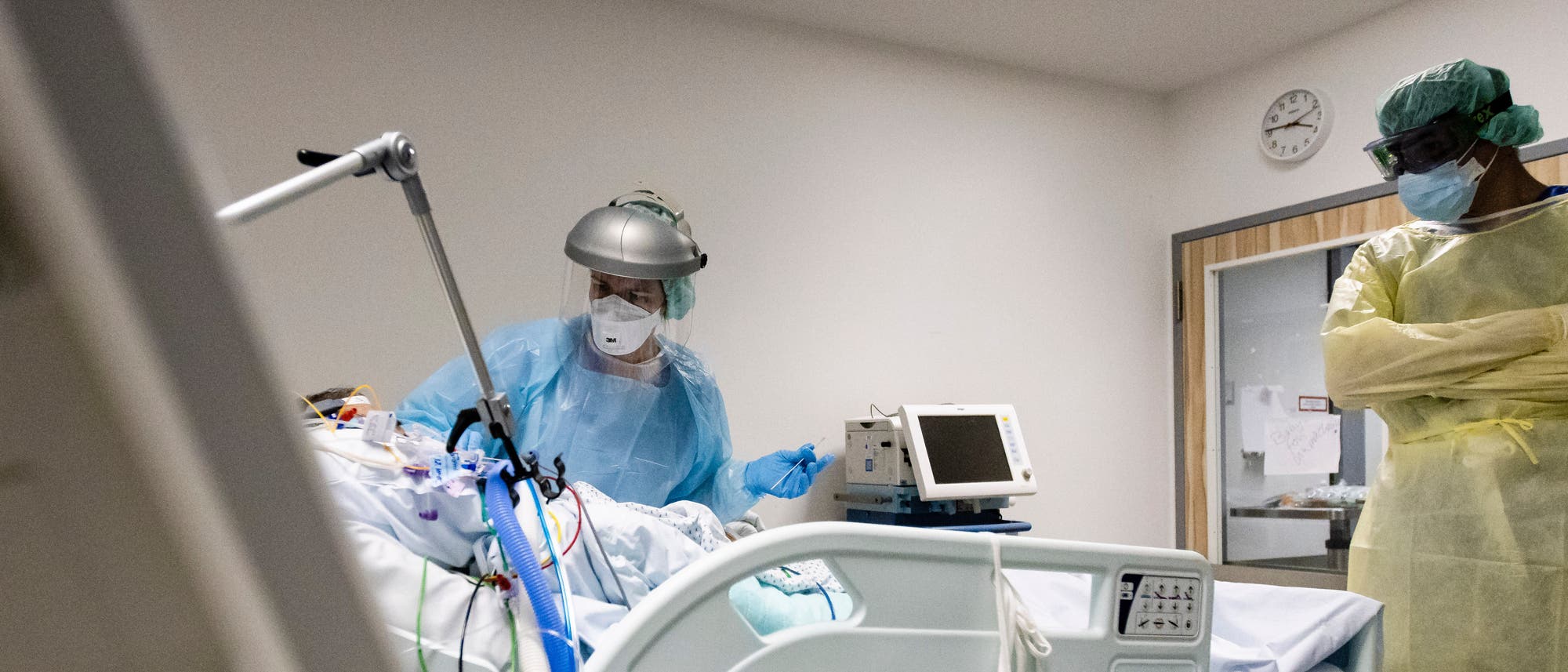 Johanna Hinrichsen (l), Fachkrankenschwester für Intensivpflege am Universitätsklinikum Schleswig-Holstein, und Steffen Ochs, Teamleiter Pflege, stehen am Bett eines am Coronavirus erkrankten Patienten. Johanna Hinrichsen (l), Fachkrankenschwester für Intensivpflege am Universitätsklinikum Schleswig-Holstein, und Steffen Ochs, Teamleiter Pflege, stehen am Bett eines am Coronavirus erkrankten Patienten.