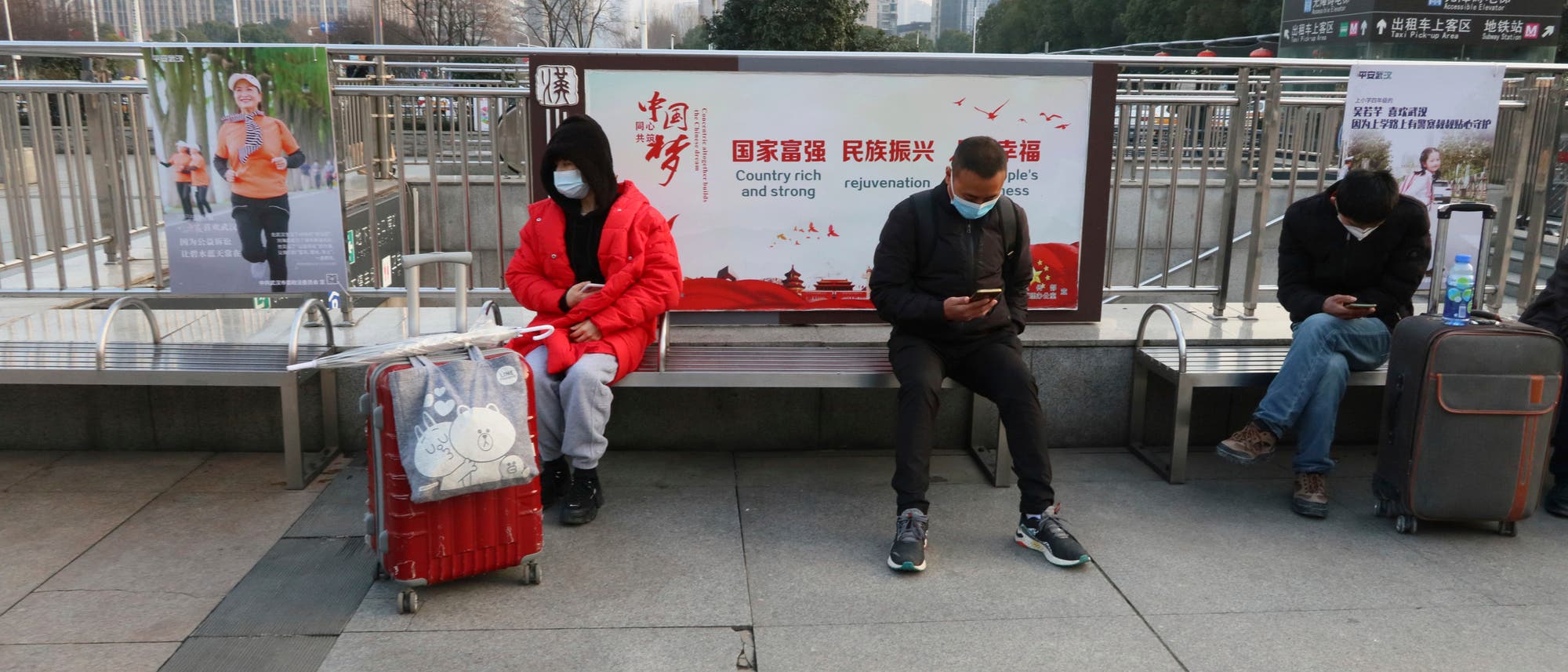 Menschen mit Masken sind am 5. Februar 2021 in der Nähe des Bahnhofs Hankou in Wuhan City, Provinz Hubei, China. Menschen mit Masken sind am 5. Februar 2021 in der Nähe des Bahnhofs Hankou in Wuhan City, Provinz Hubei, China.
