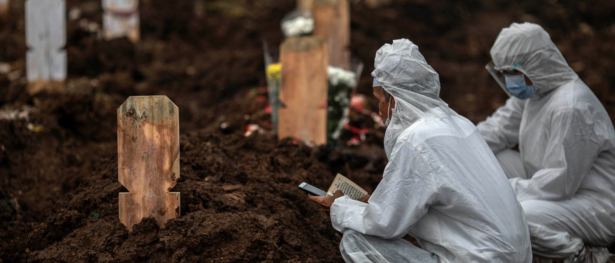 Ein Kleriker spricht das letzte Gebet für einen Menschen, der an den Folgen von Covid 19 in Süd-Jakarta, Indonesien, gestorben ist.