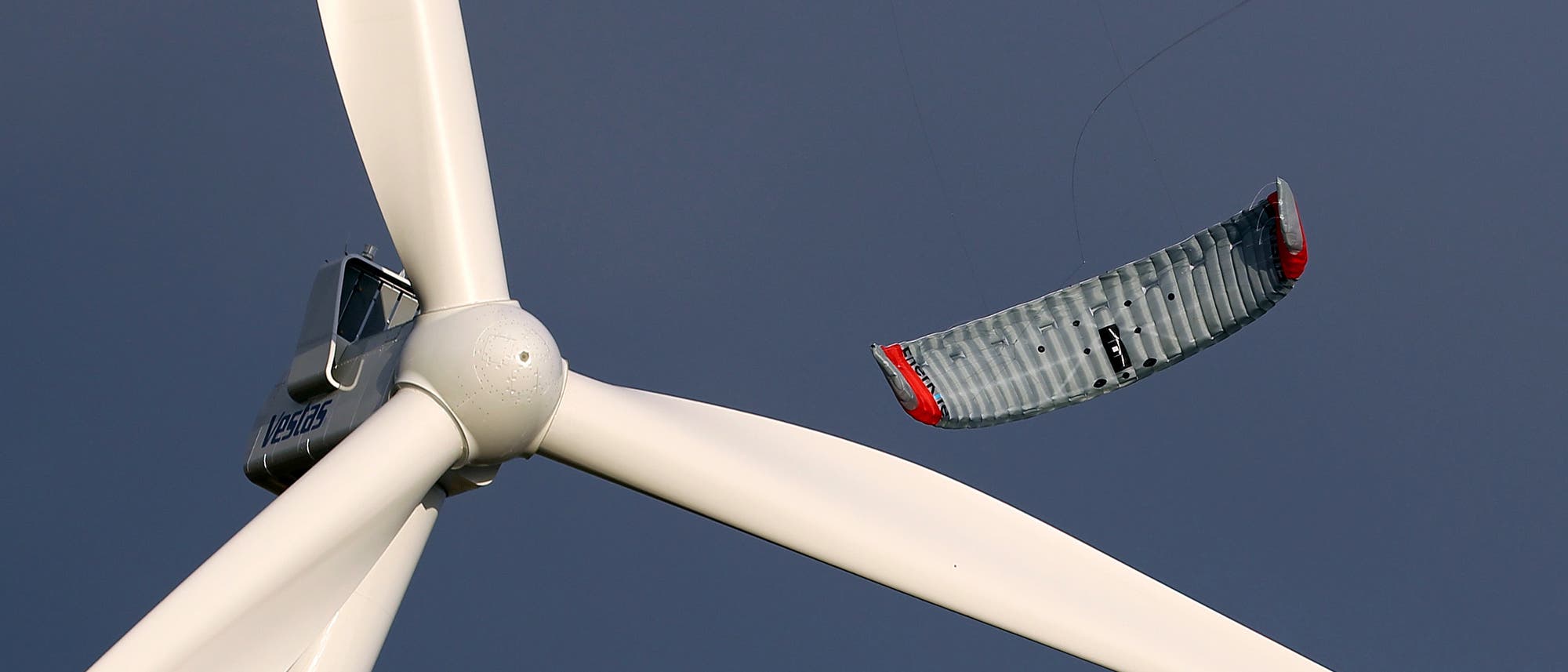 Der Prototyp eines Windenergie-Drachens hinter dem Rotor eines stationären Windrads. Der Prototyp eines Windenergie-Drachens hinter dem Rotor eines stationären Windrads.