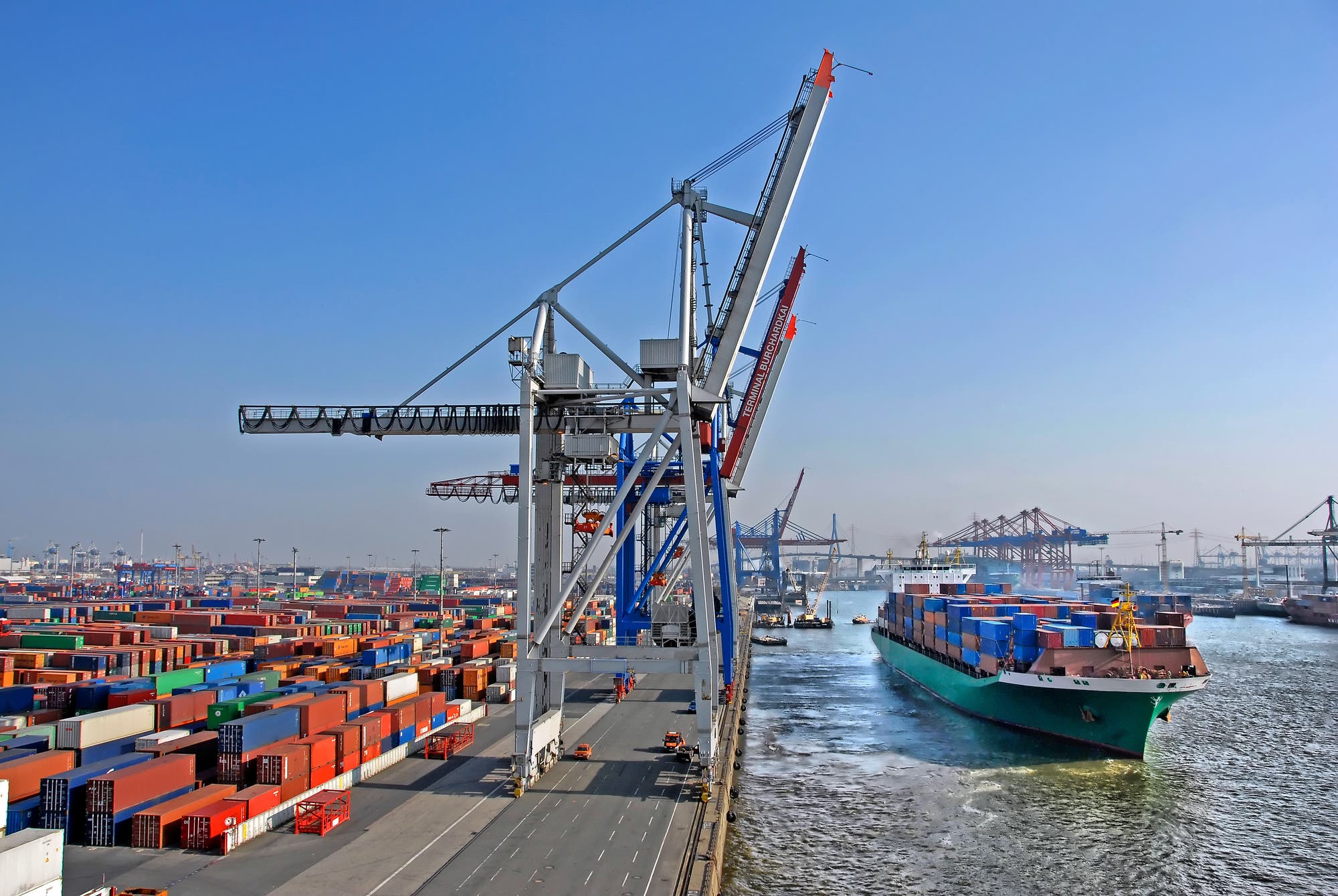 Containerterminal Hamburg-Altenwerder mit einlaufendem Schiff, Containerbrücken und der Köhlbrandbrücke im Hintergrund