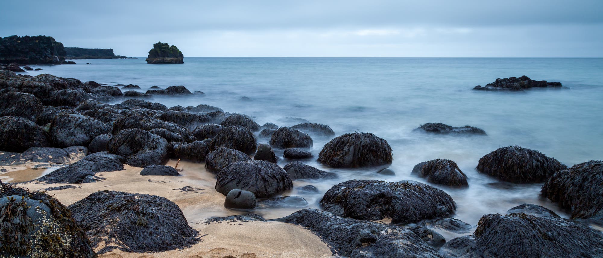 Vulkanisches Gestein an einem Sandstrand Vulkanisches Gestein an einem Sandstrand
