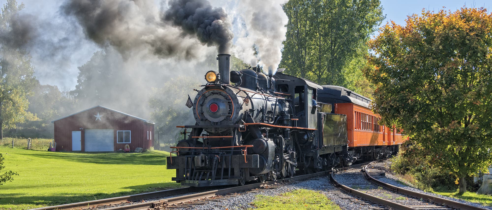 Eine alte Dampflokomotive zieht einen Zug durch den ländlichen Raum. Eine alte Dampflokomotive zieht einen Zug durch den ländlichen Raum.