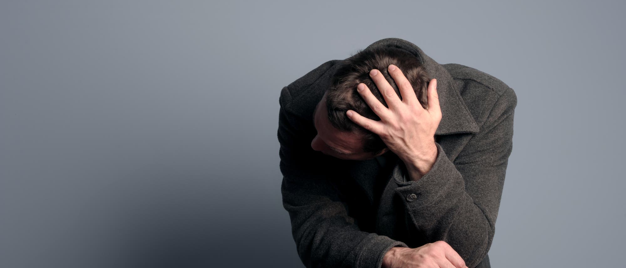 Erschöpfter Mann stützt sich auf einem Stuhl ab Erschöpfter Mann stützt sich auf einem Stuhl ab