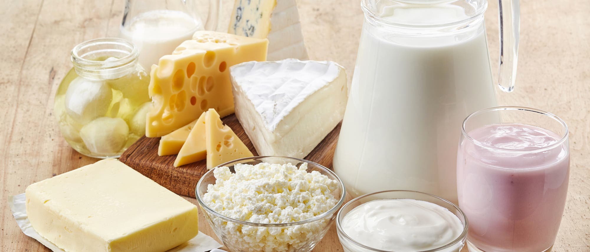 Milch, Käse, Joghurt und Co, drapiert auf einem Holztisch Milch, Käse, Joghurt und Co, drapiert auf einem Holztisch