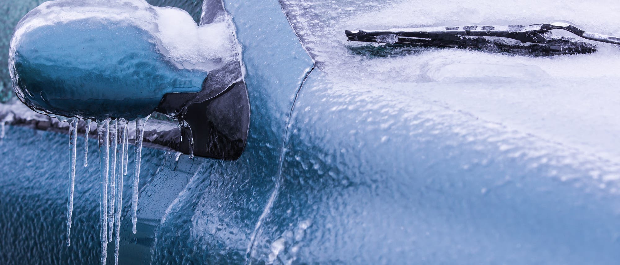 Eiskruste auf Außenspiegel und Scheibenwischer eines Autos Eiskruste auf Außenspiegel und Scheibenwischer eines Autos