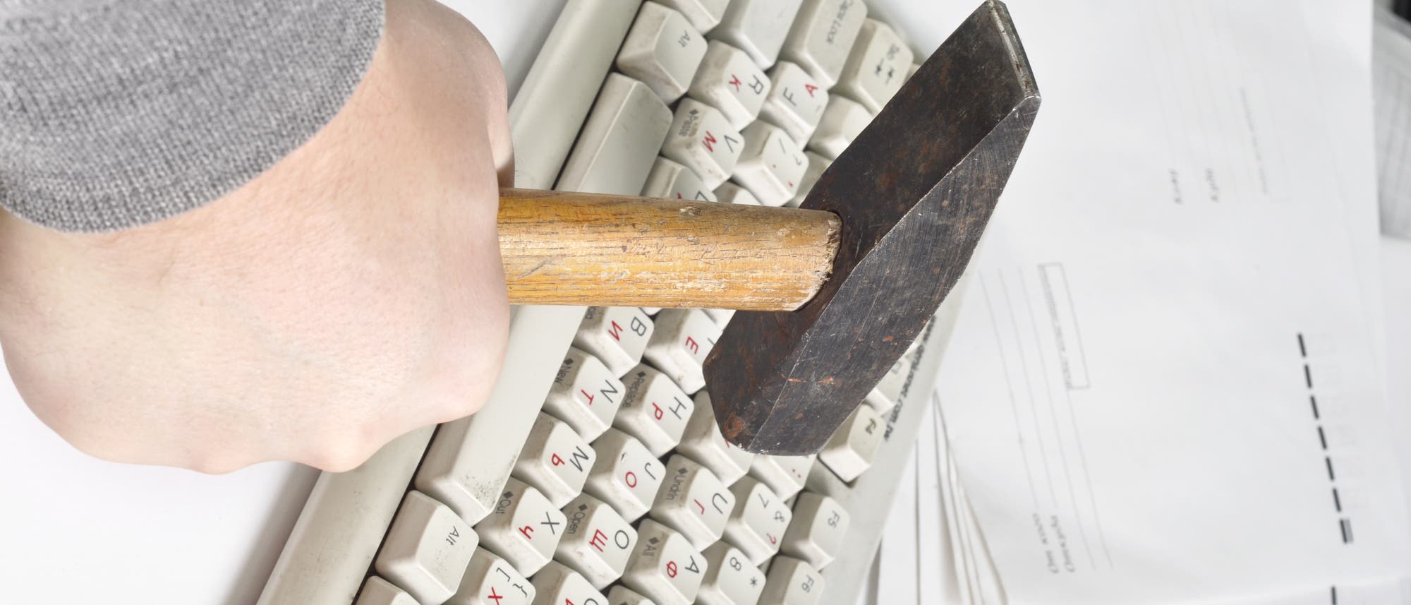 Ein Hammer trifft eine Tastatur Ein Hammer trifft eine Tastatur