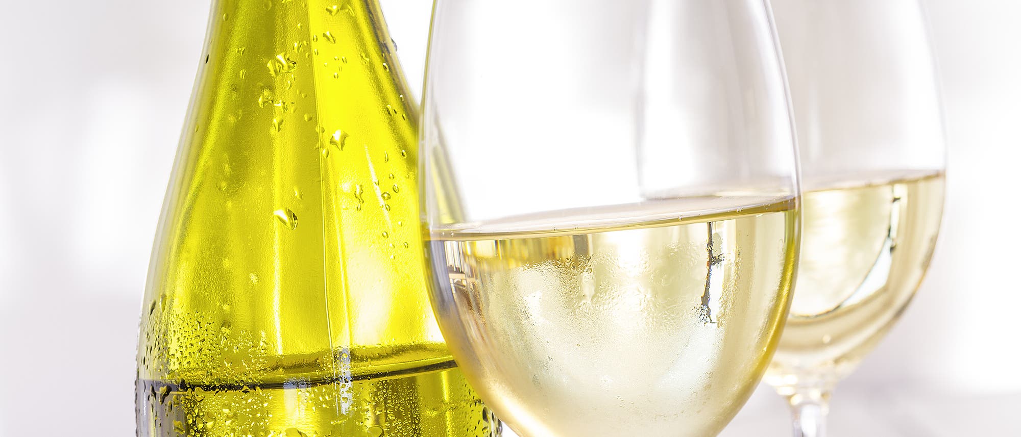 Weißwein in der Flasche und in zwei Gläsern, Nahaufnahme Weißwein in der Flasche und in zwei Gläsern, Nahaufnahme