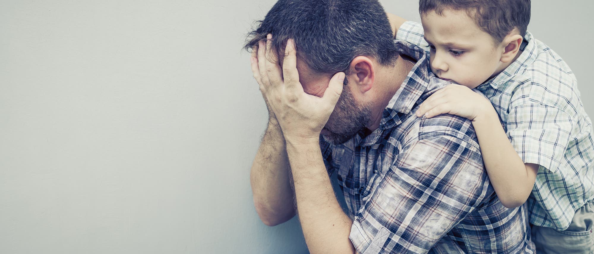 Vater und Sohn vor weißer Wand Vater und Sohn vor weißer Wand