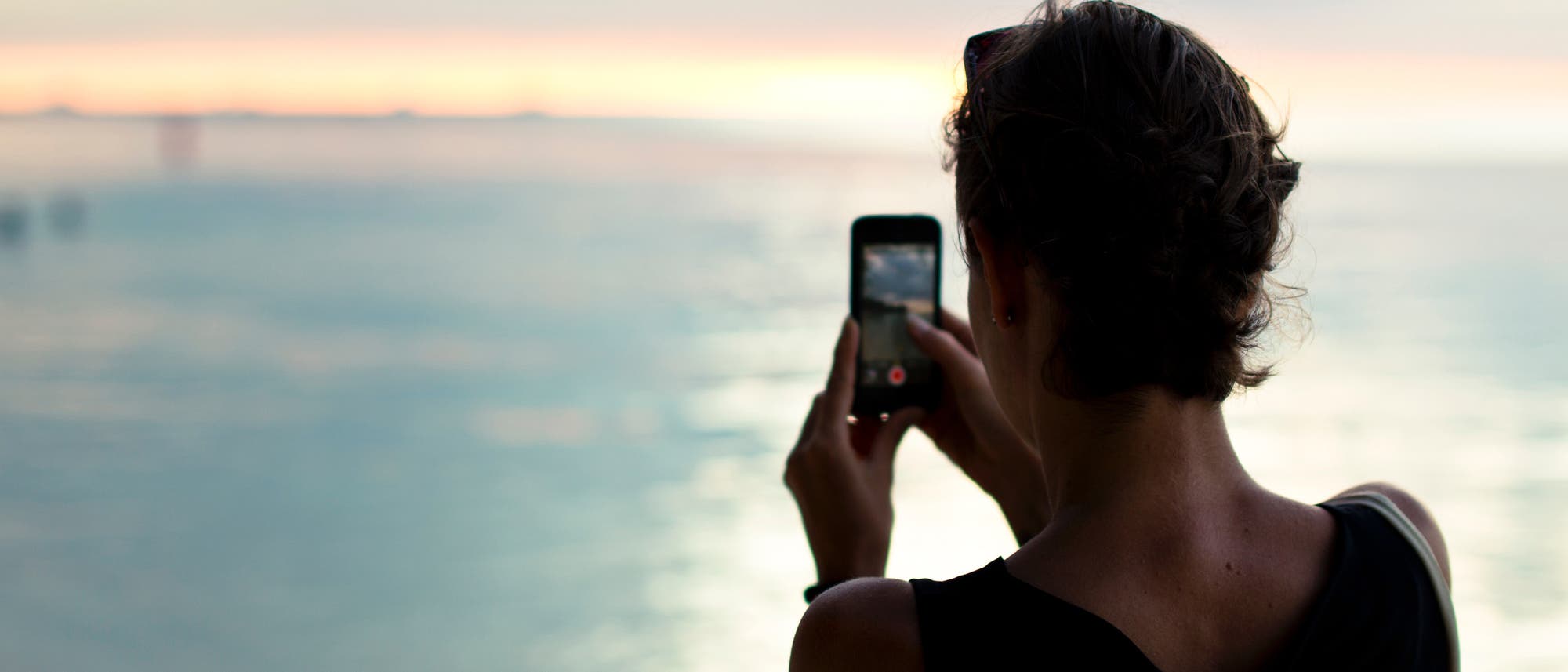 Frau macht Foto vom Sonnenuntergang Frau macht Foto vom Sonnenuntergang