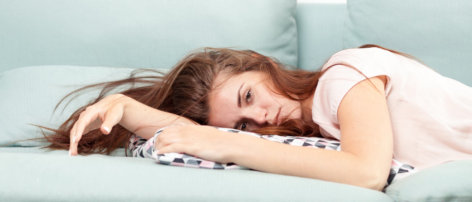 Frau liegt erschöpft auf dem Sofa Frau liegt erschöpft auf dem Sofa