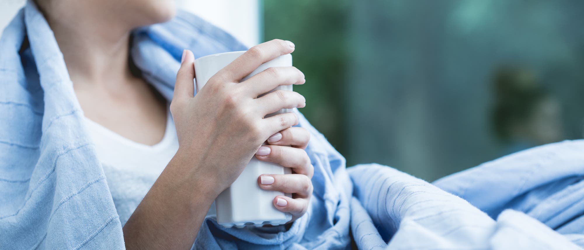 Kranke Frau mit Tasse Tee im Bett Kranke Frau mit Tasse Tee im Bett