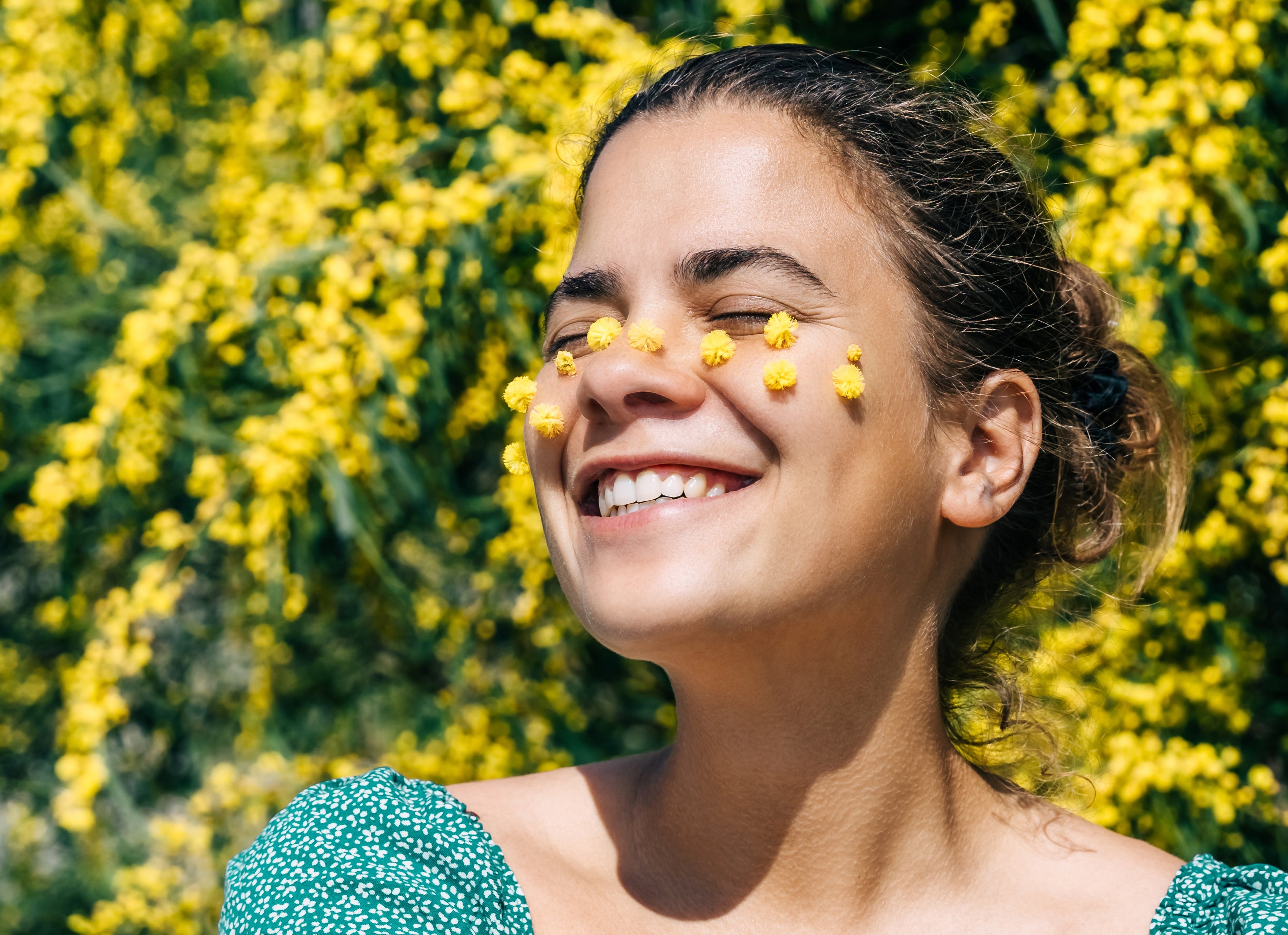 lachendes Mädchen mit Blumen im Gesicht