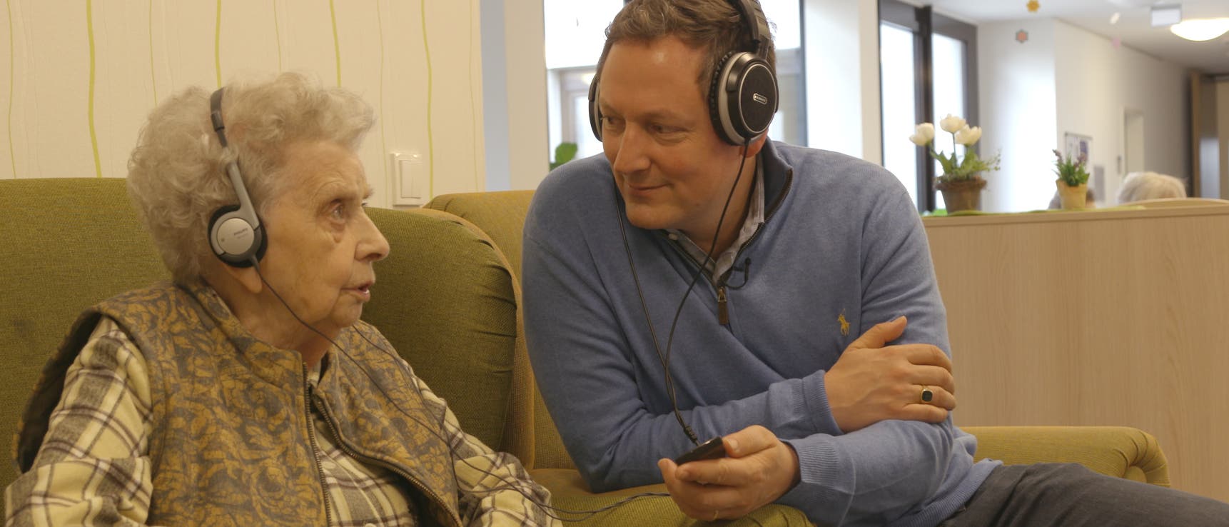 Eckart von Hirschhausen hört gemeinsam mit einer älteren Dame Musik Eckart von Hirschhausen hört gemeinsam mit einer älteren Dame Musik