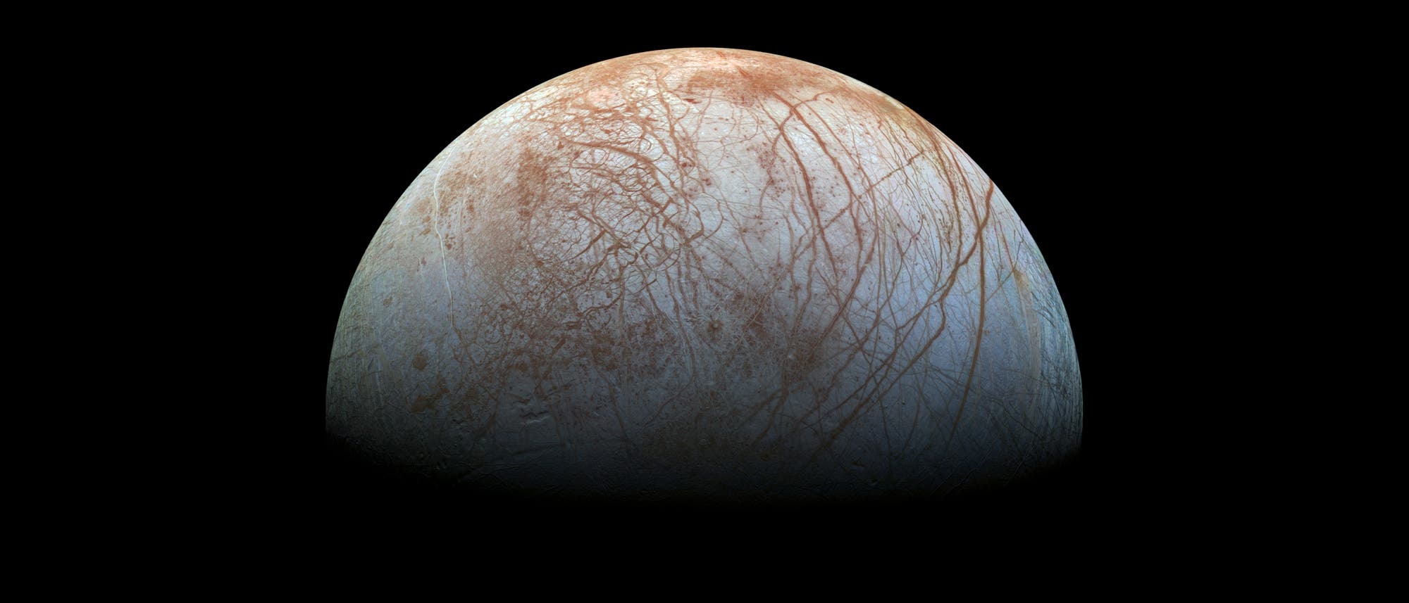 Der Jupitermond Europa hat eine Oberfläche aus Eis, über das gezackte, rotbraune Risse laufen. Der Jupitermond Europa hat eine Oberfläche aus Eis, über das gezackte, rotbraune Risse laufen.