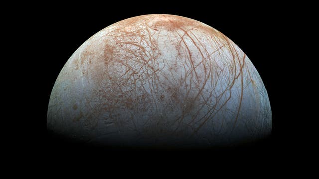 Der Jupitermond Europa hat eine Oberfläche aus Eis, über das gezackte, rotbraune Risse laufen.