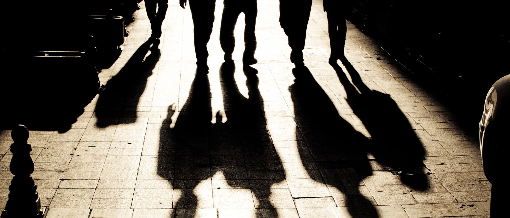 Schatten von Männern auf einer Straße Schatten von Männern auf einer Straße
