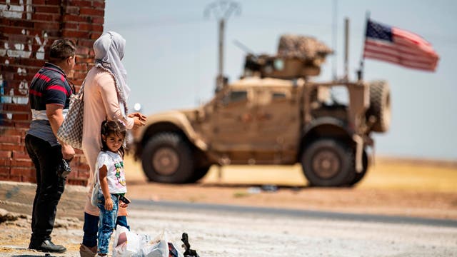Menschen in Syrien beobachten ein US-Militärfahrzeug.