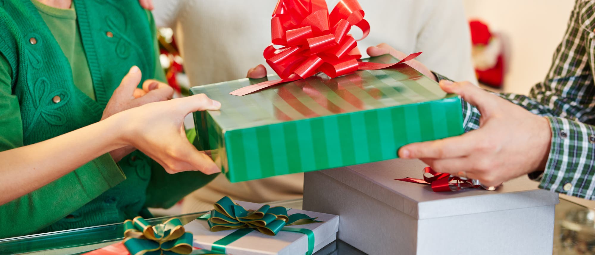 Zwei Menschen beschenken sich. Ein Mann übergibt einer Frau ein Geschenk. Zwei Menschen beschenken sich. Ein Mann übergibt einer Frau ein Geschenk.