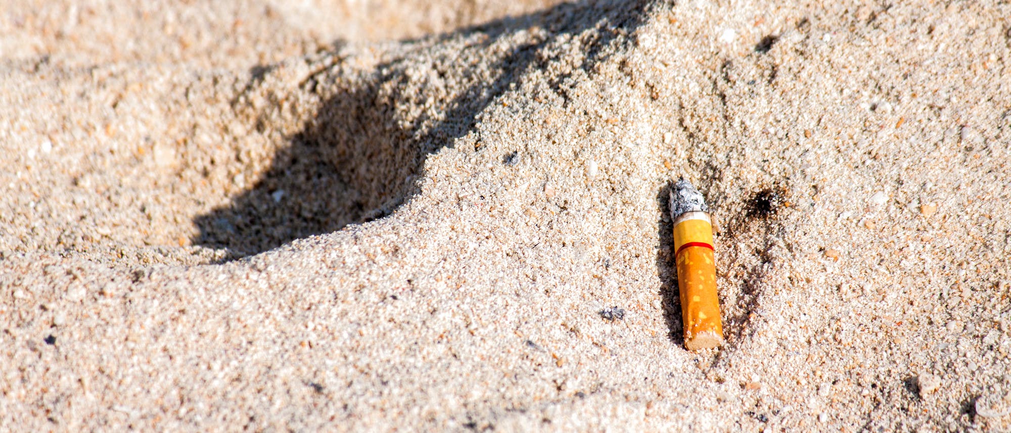 Zigarettenkippe am Strand Zigarettenkippe am Strand