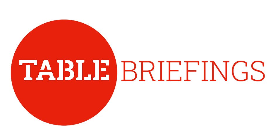 Ein Logo mit einem großen roten Kreis auf der linken Seite. Innerhalb des Kreises steht in weißer Schrift das Wort "TABLE". Rechts daneben, außerhalb des Kreises, steht in roter Schrift das Wort "BRIEFINGS". Das Design kombiniert kräftige Farben und klare Typografie.