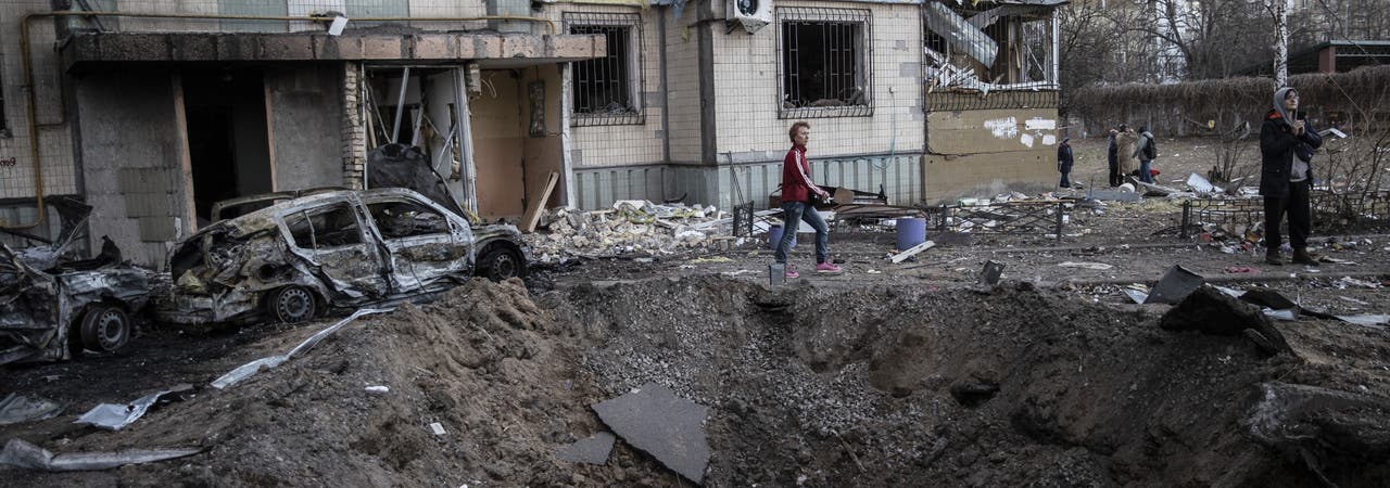 Zivilisten sammeln ihre Habseligkeiten inmitten der Trümmer eines Wohnhauses in Kiew, Ukraine, am 20. März 2022. 