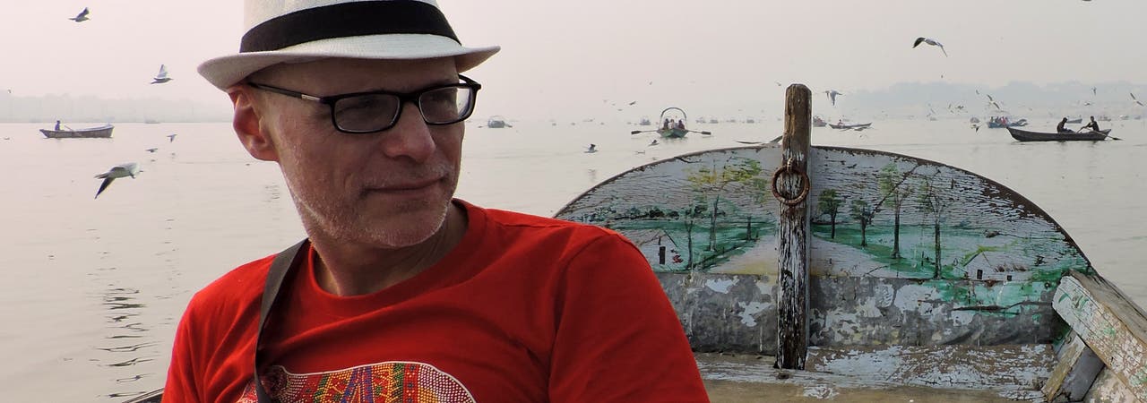 Der Psychologe Arne Dietrich sitzt auf einem Boot. Im Hintergrund sind weitere Boote und Vögel zu sehen.